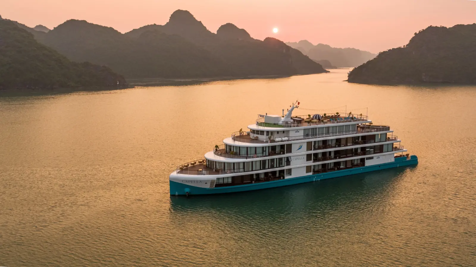 Capella Cruise on golden water among the karsts