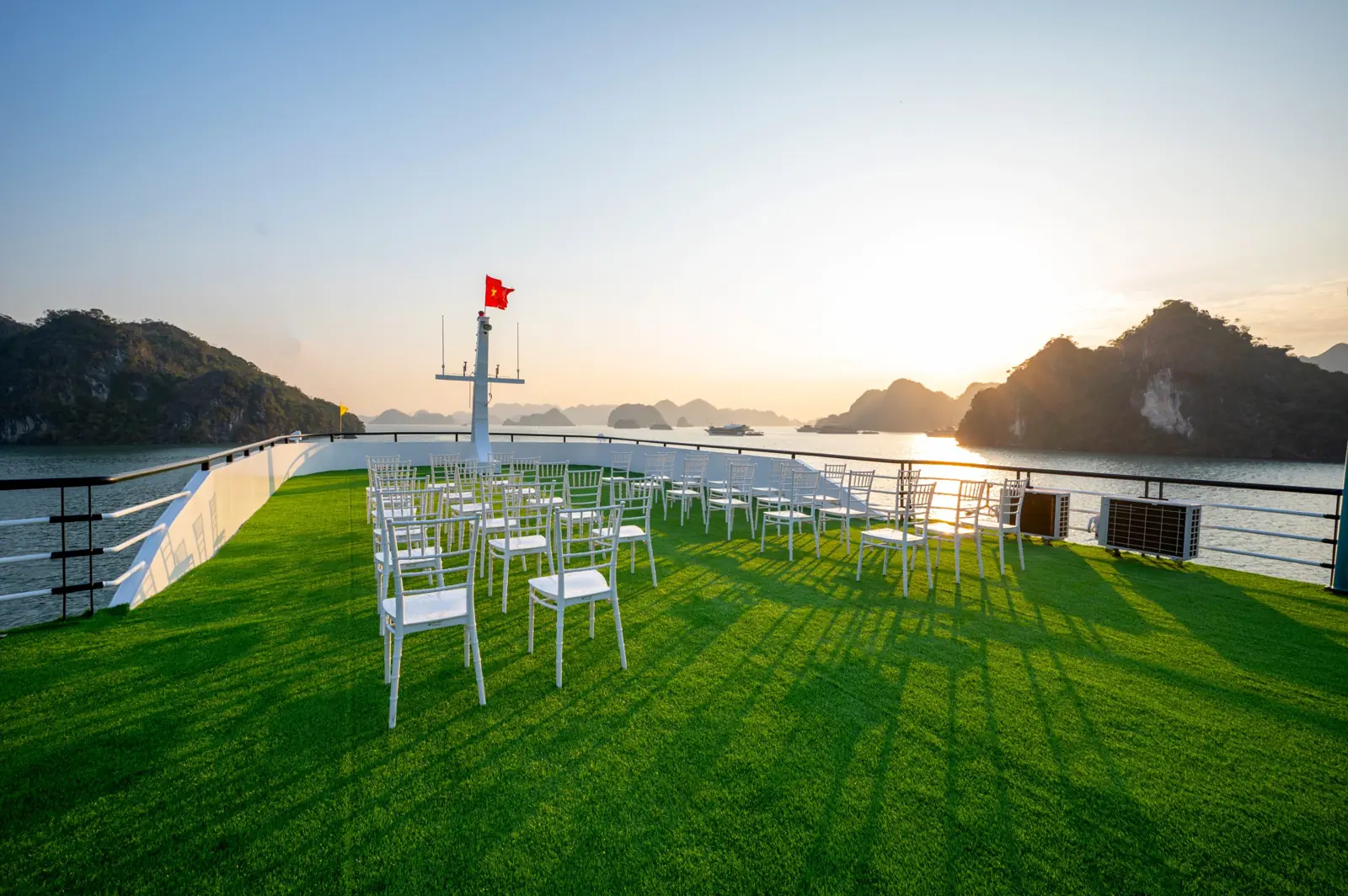 Lawn sundeck with white chairs at sunset