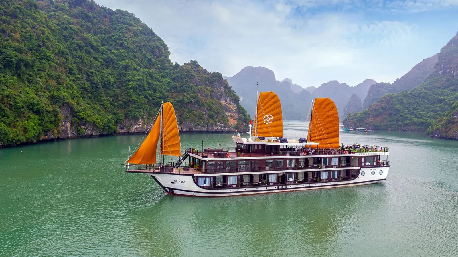 Peony Cruise with its orange sails among the karsts