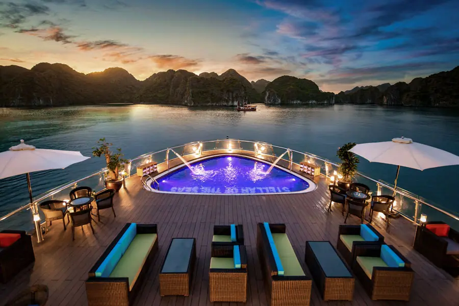Pool deck of Stellar of the Seas lit up at sunset