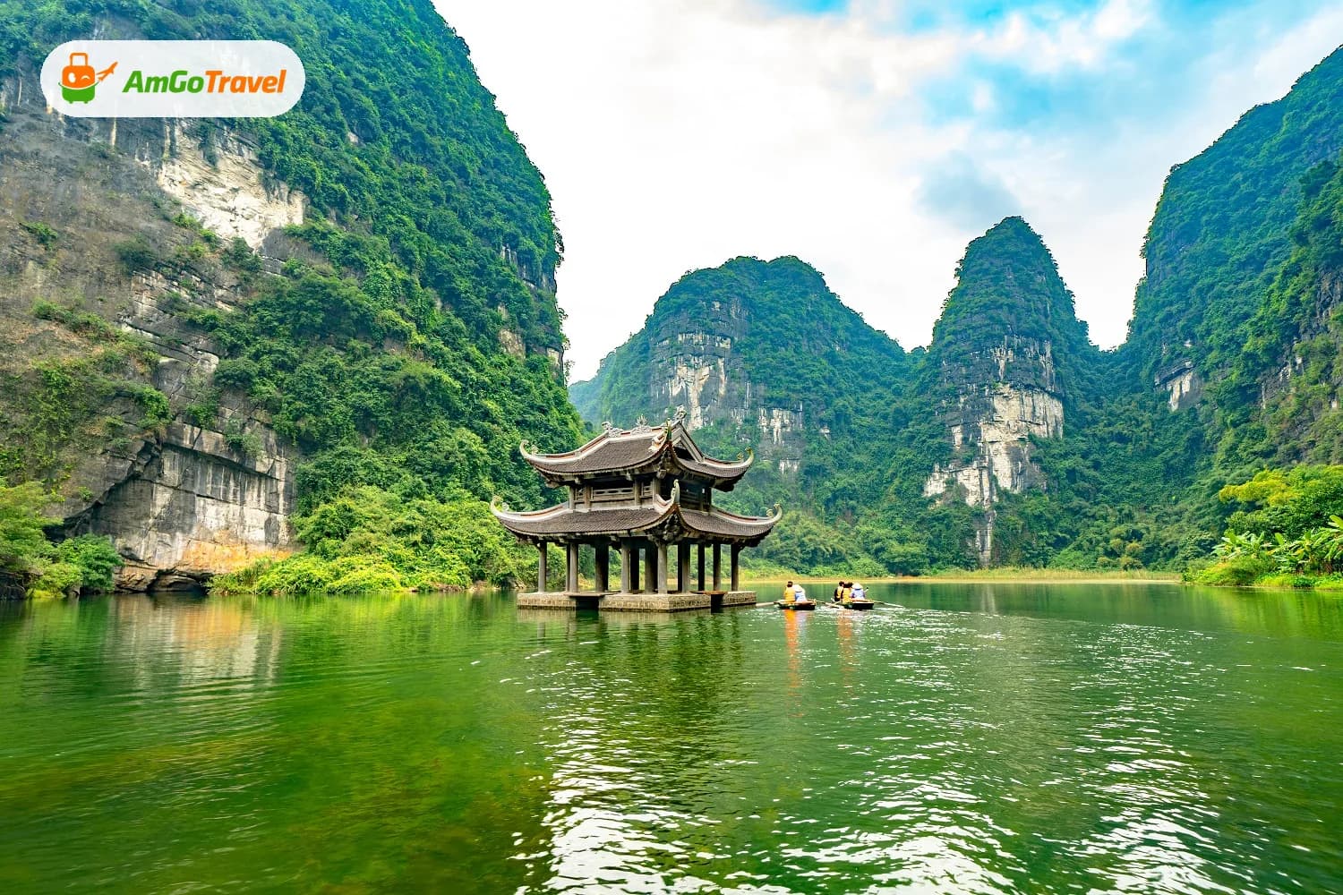 Pavilion on emerald water beneath Trang An karst peaks
