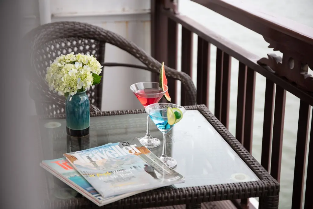 A drink on a cabin balcony facing the bay