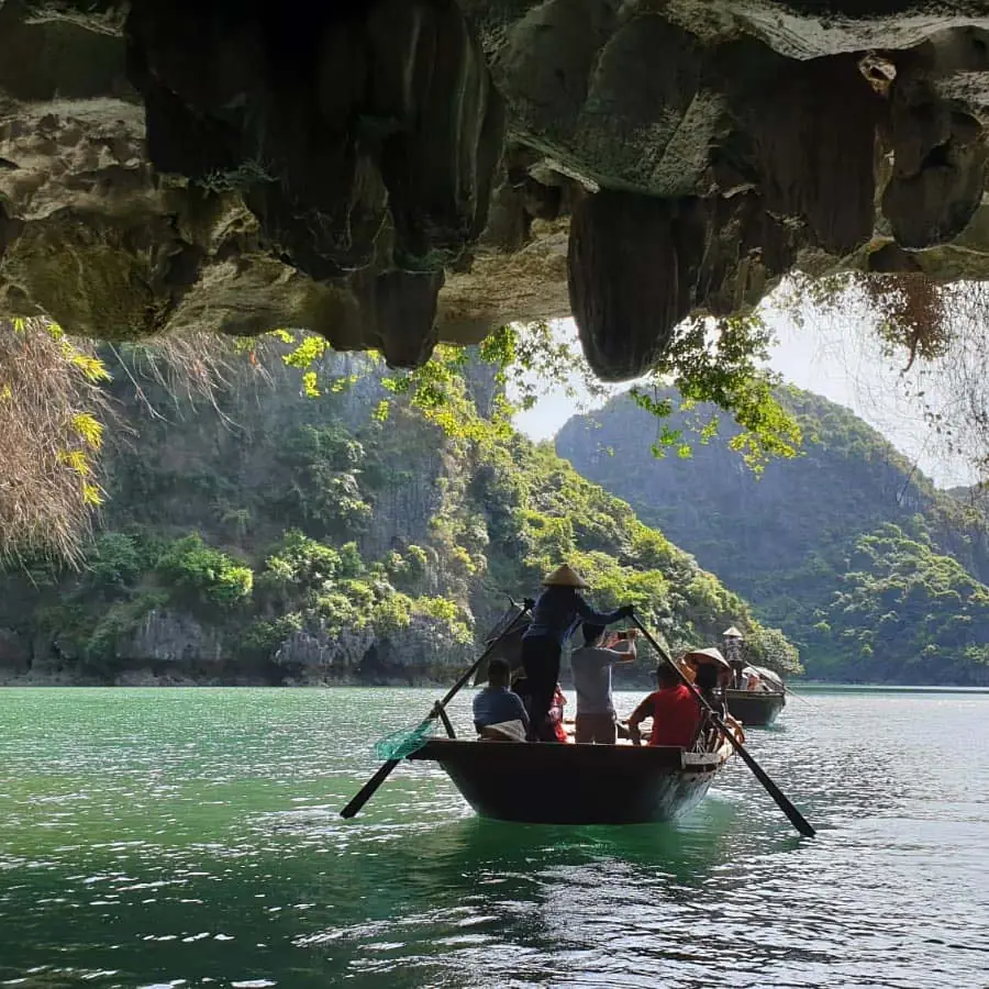 Rowing boat under a rock arch in Lan Ha Bay
