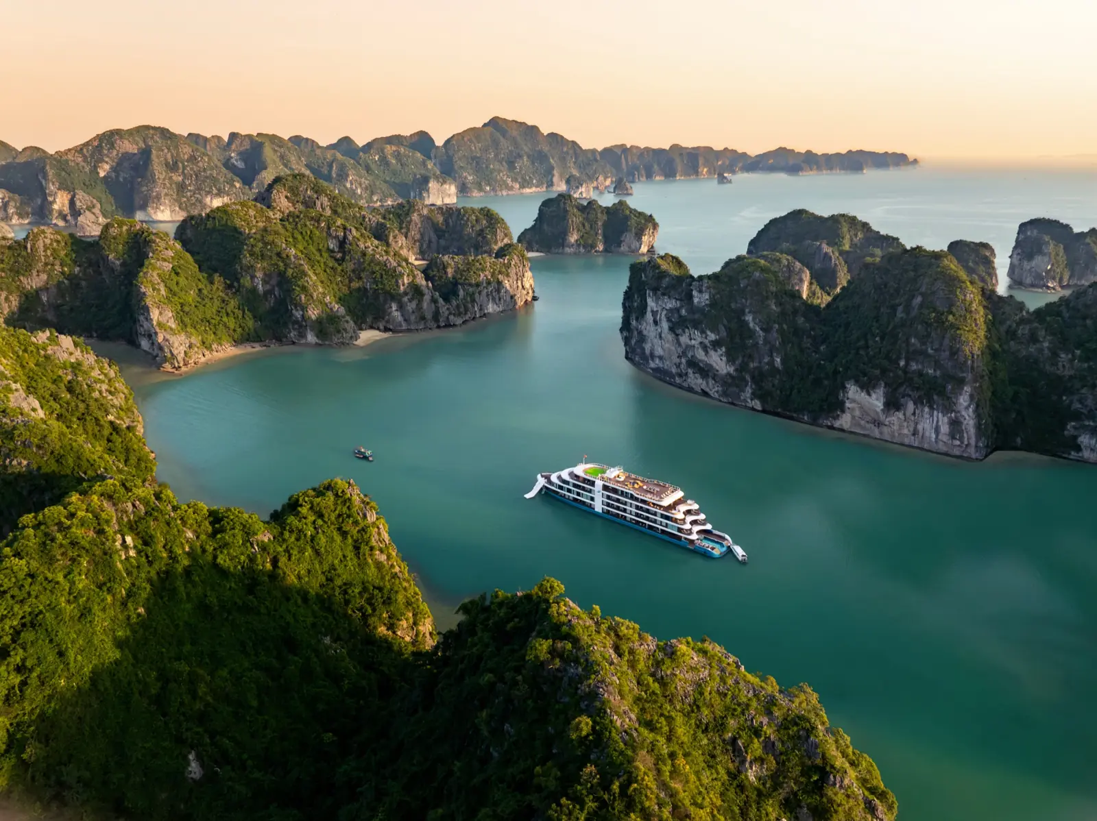 Lyra Grandeur cruising among the green karsts of Lan Ha Bay, seen from above